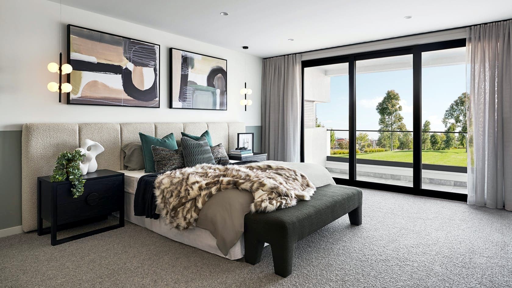 bedroom with extra wide white boucle headboard black bedside tables and abstract artwork