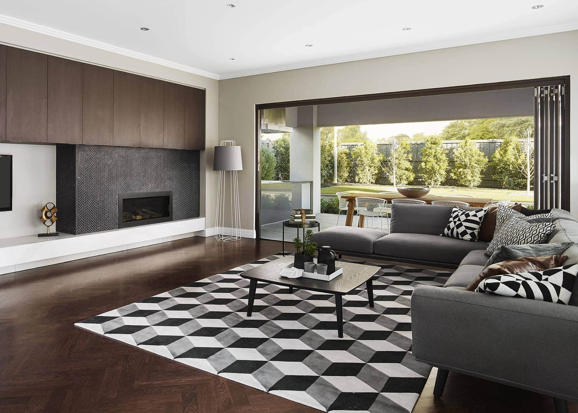 black and white geometric rug in living room with dark herringbone timber floor