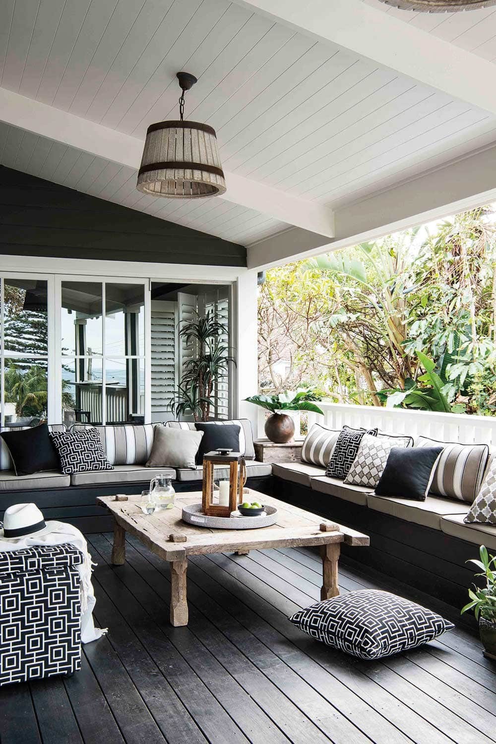 black and white outdoor room with pendant light pitched ceiling and decking