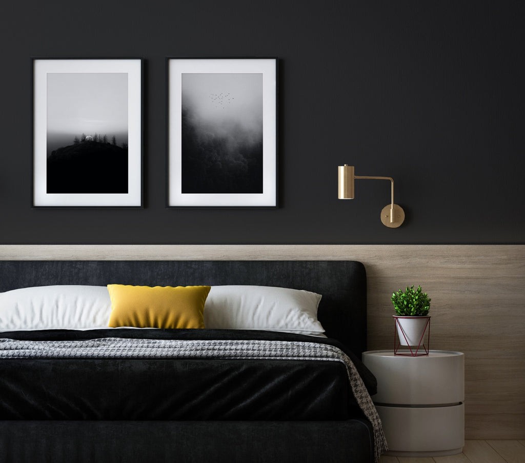 black bedroom with moody black and white artworks above bed