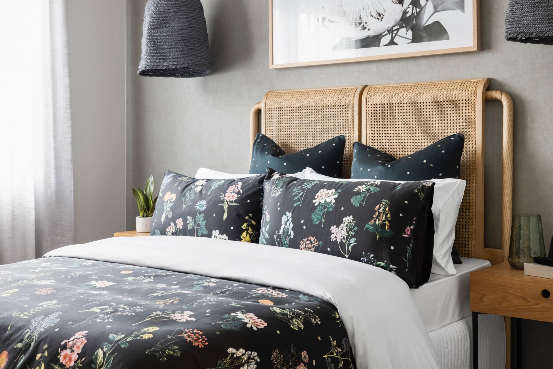 black floral quilt cover set in nature bedroom with rattan headboard and timber bedside tables