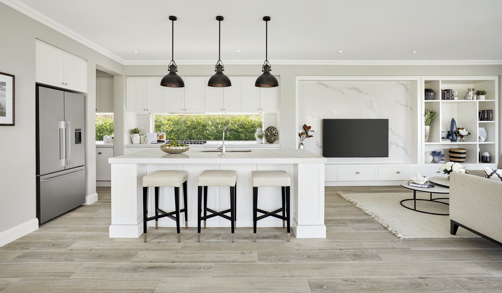black industrial pendant lights over island in traditional hamptons kitchen