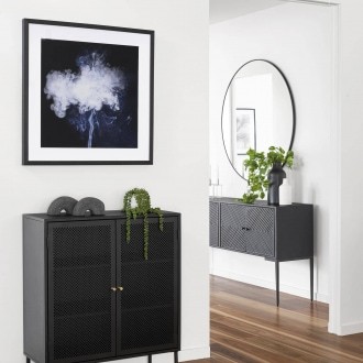 black metal storage unit and black globewest side table in entryway with fake plants