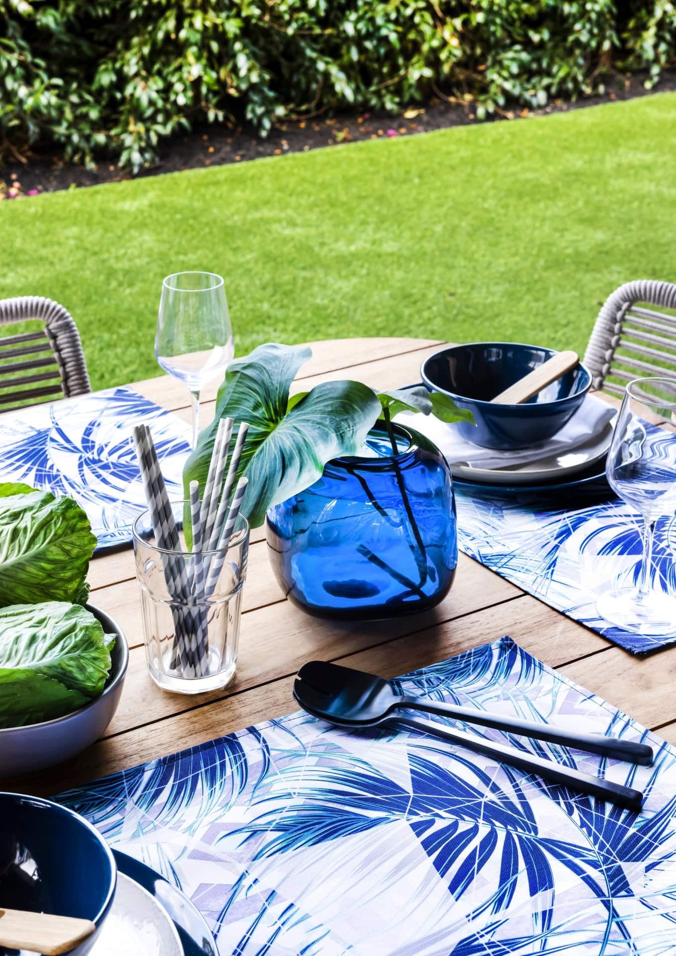 blue and white outdoor placemats on timber dining table in backyard