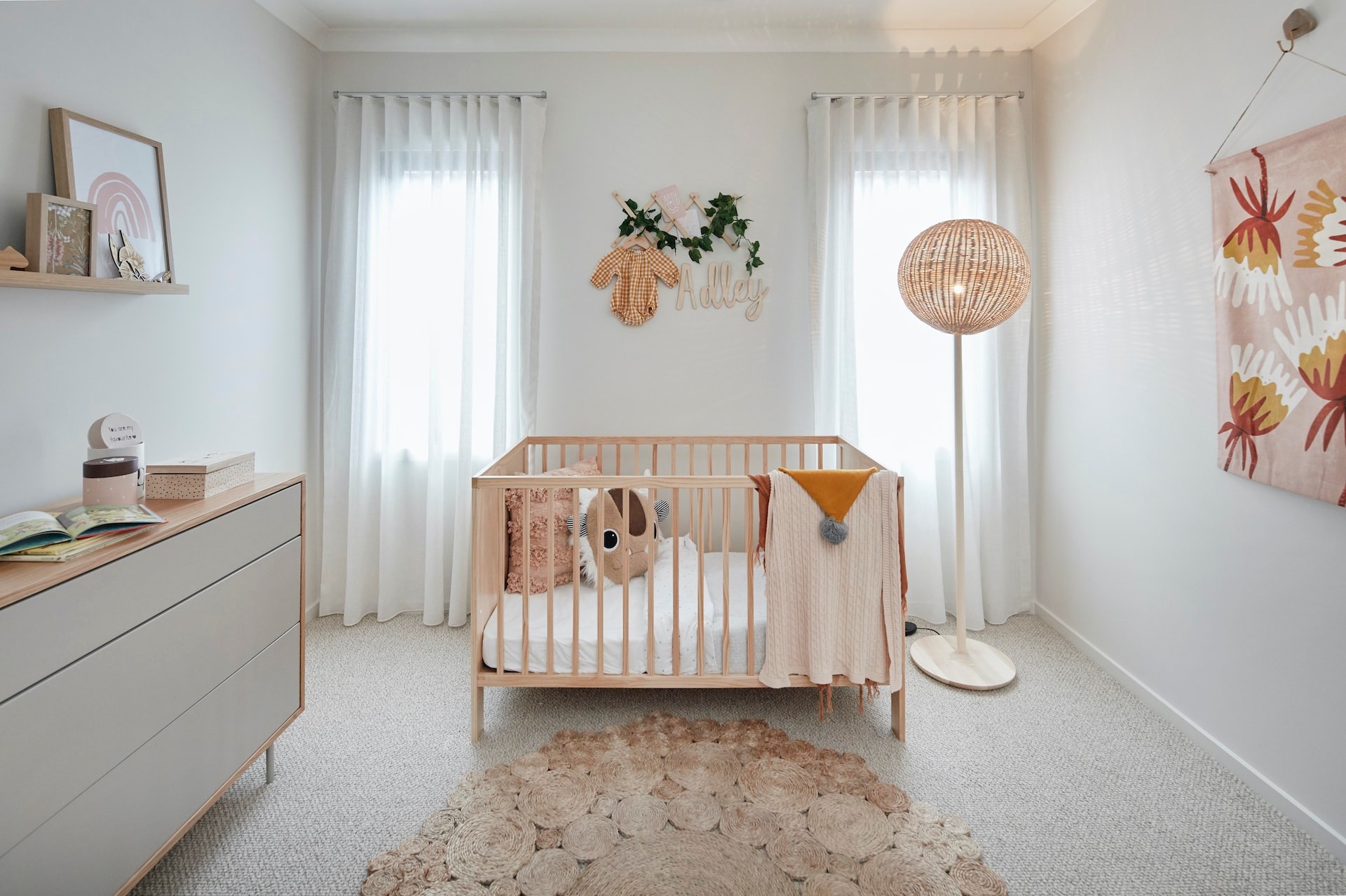bohemian nursery with blonde timber crib and sheer curtains gender neutral colours