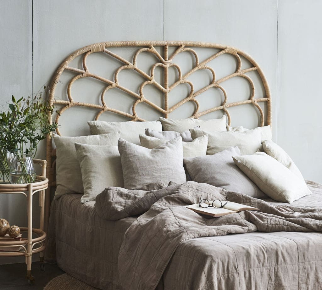 boho rattan headboard in bohemian bedroom with cushions on bed