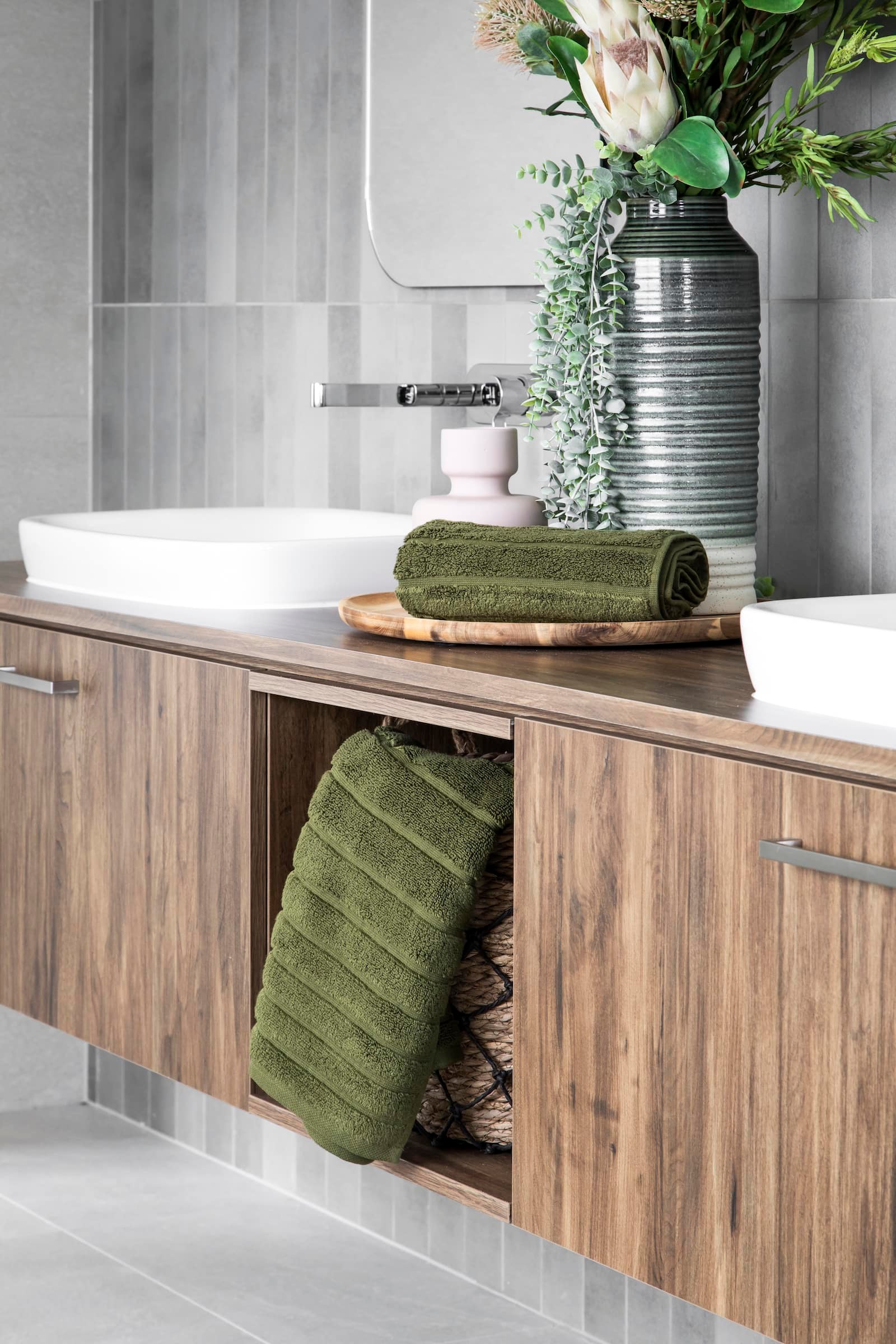 brown timber floating bathroom vanity with green towels