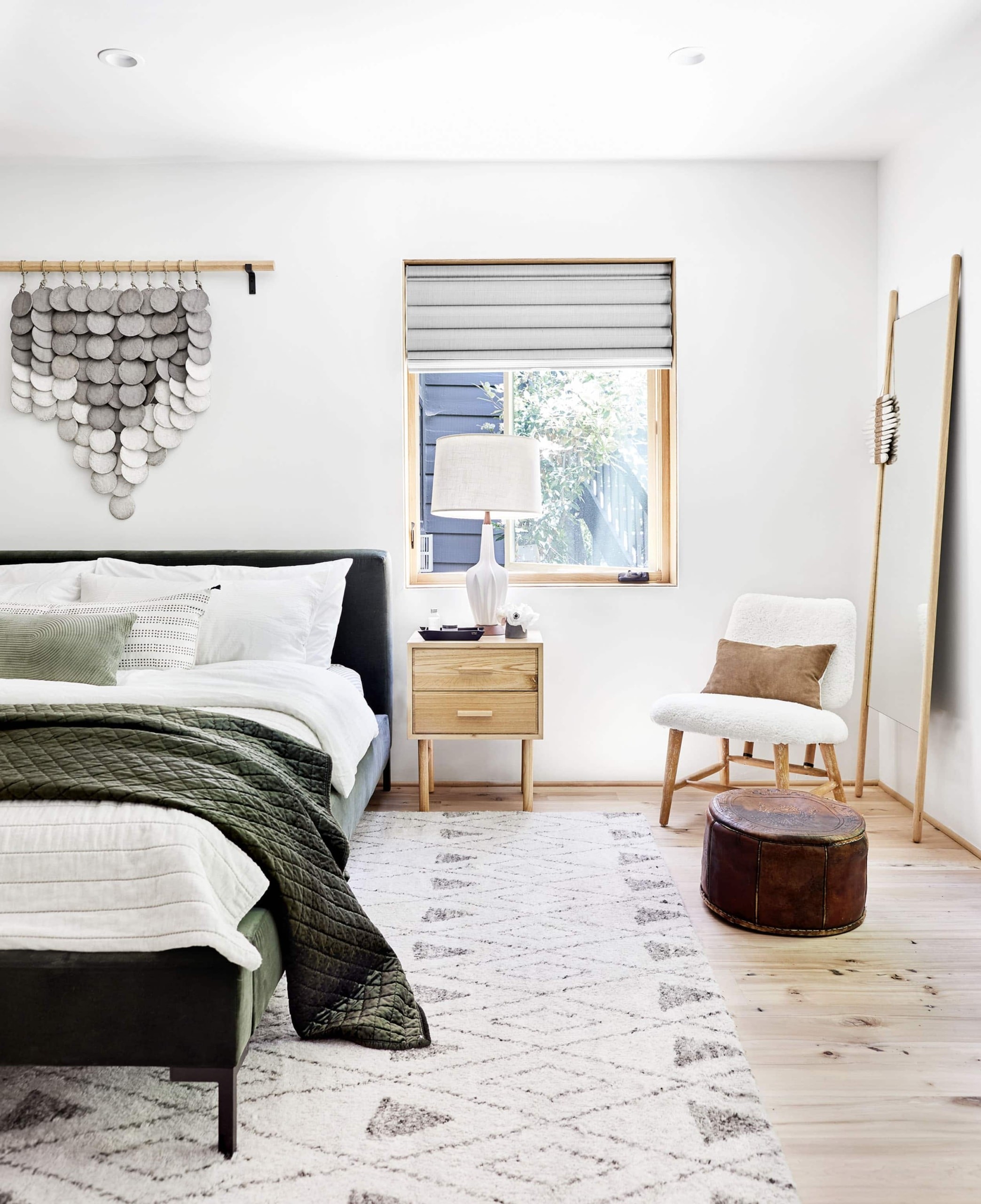 california cool bedroom with scandi bedside table mid century table lamp and textile hung above bed