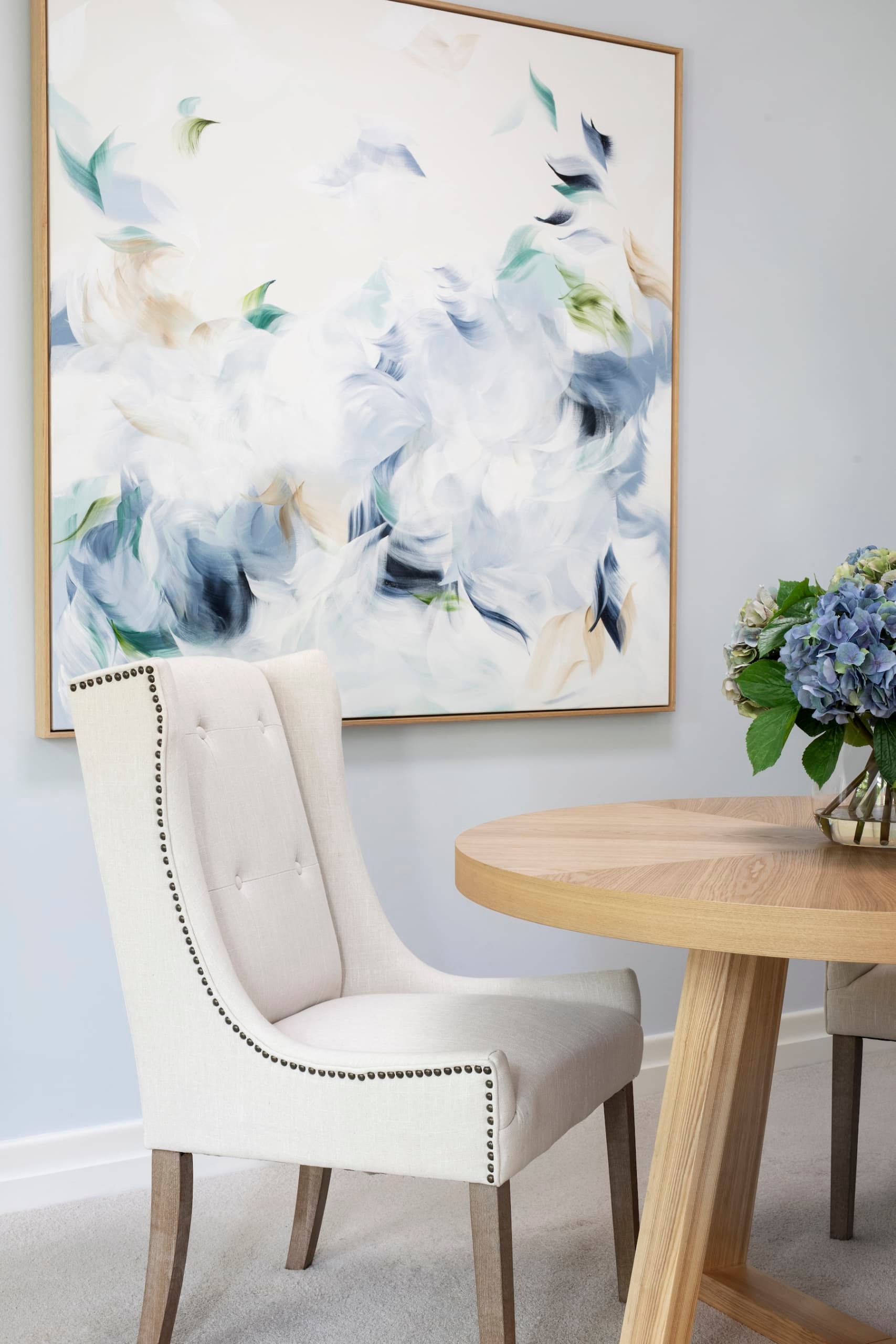 chalie macrae art in hamptons dining room with beige tufted dining chairs tlc interiors