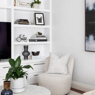 chic monochromatic living room white shelf styled with black decor white swivel armchair