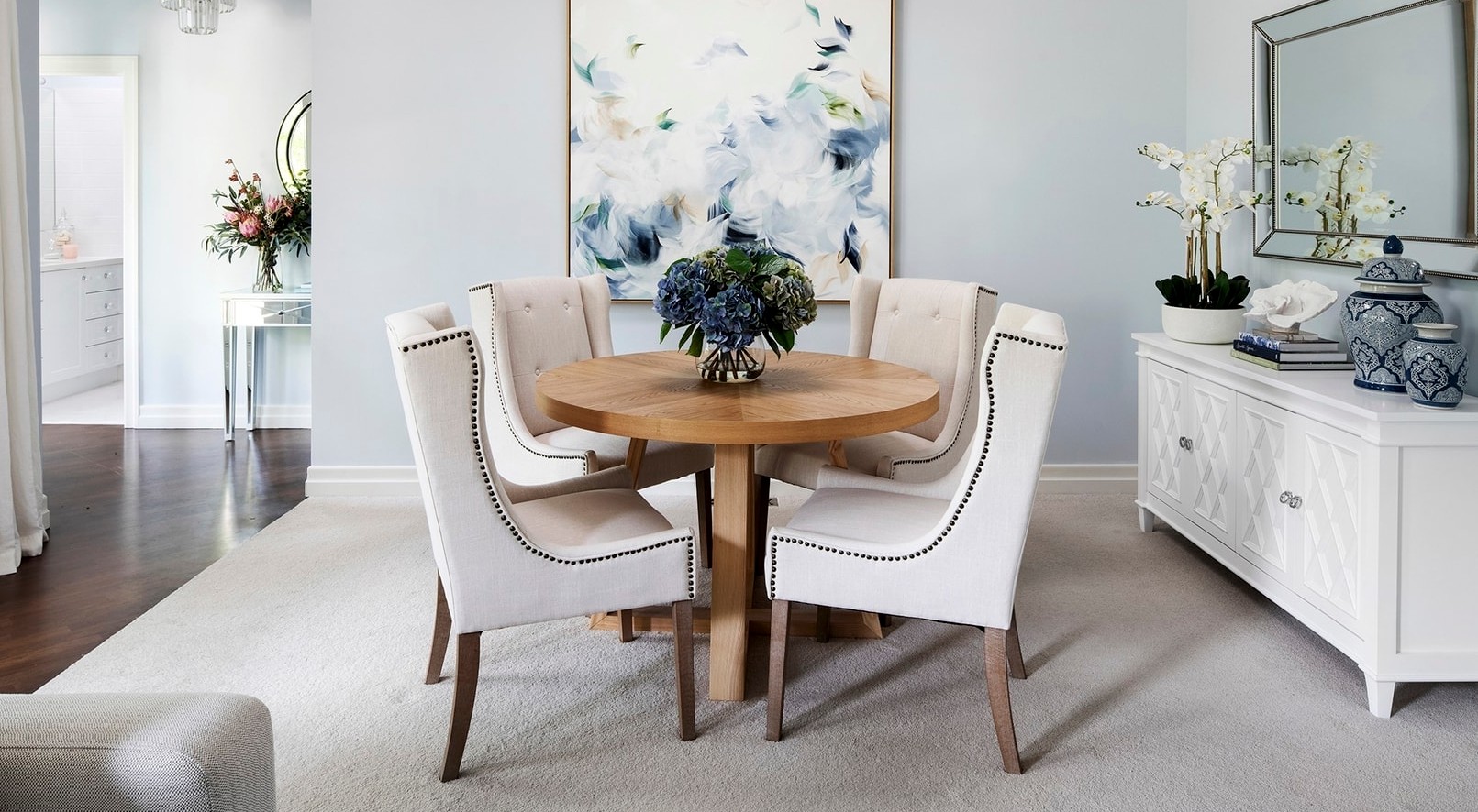 classic hamptons interior design dining room with chalie macrae art on light blue wall
