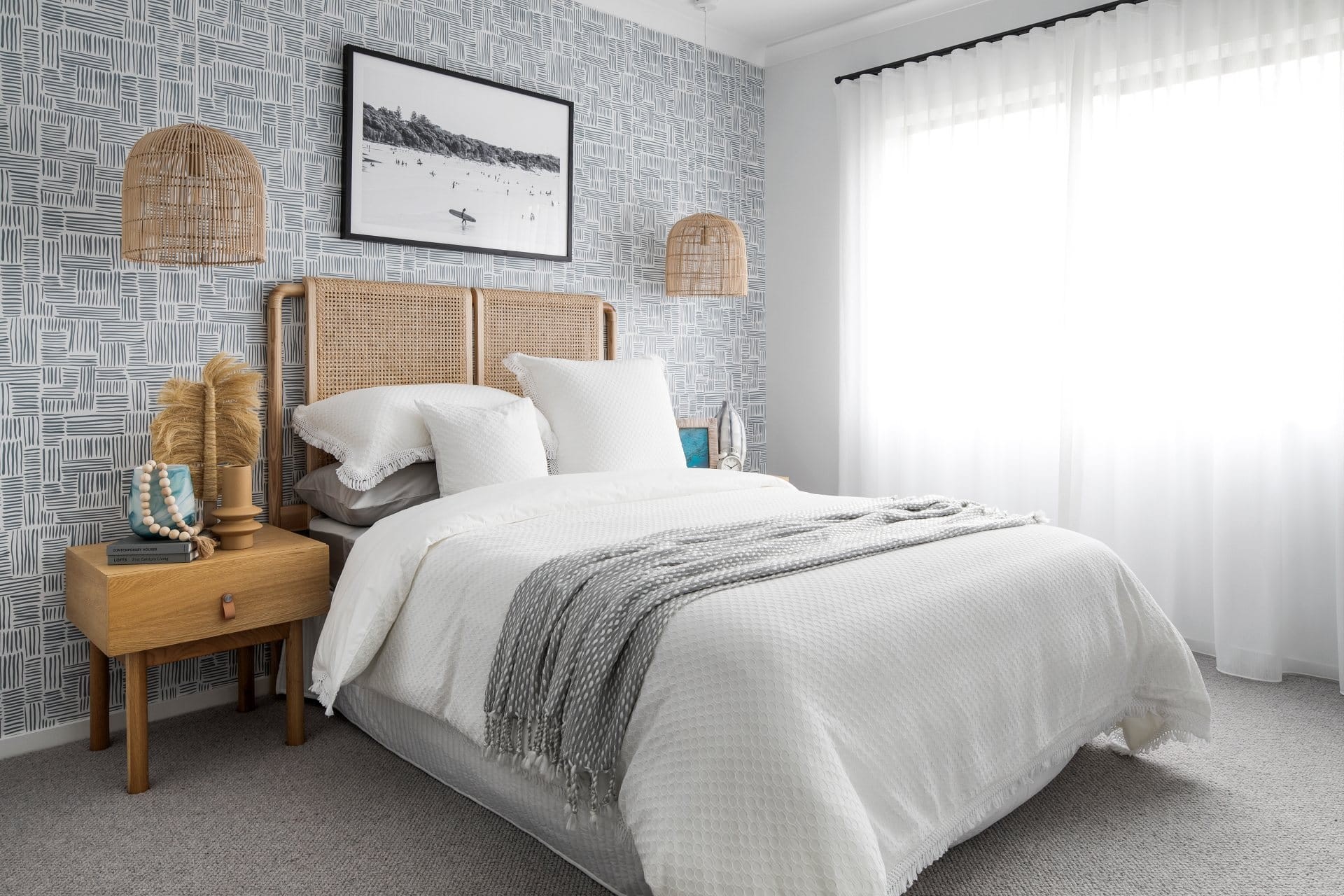 coastal bedroom with white bedding rattan pendant lights and blue wallpaper design