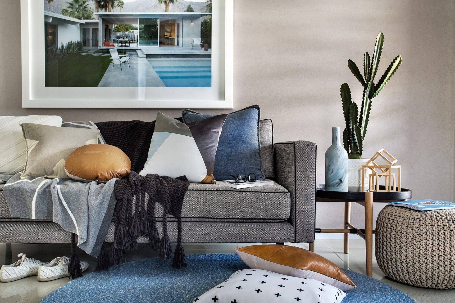 coastal living room with grey sofa and blue and tan cushions from metricon