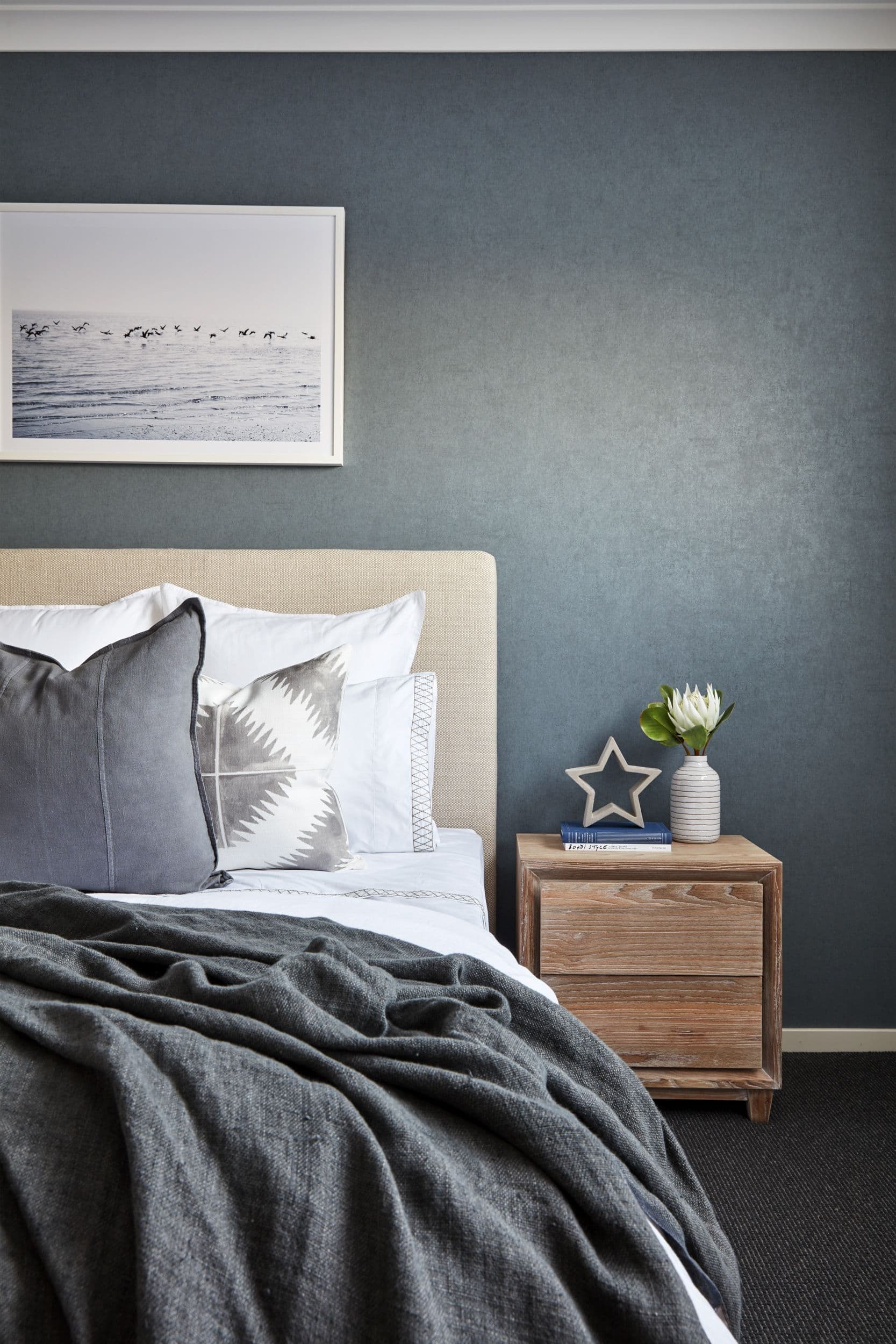 dark coastal bedroom with grey suede paint effect and coastal artwork with white frame