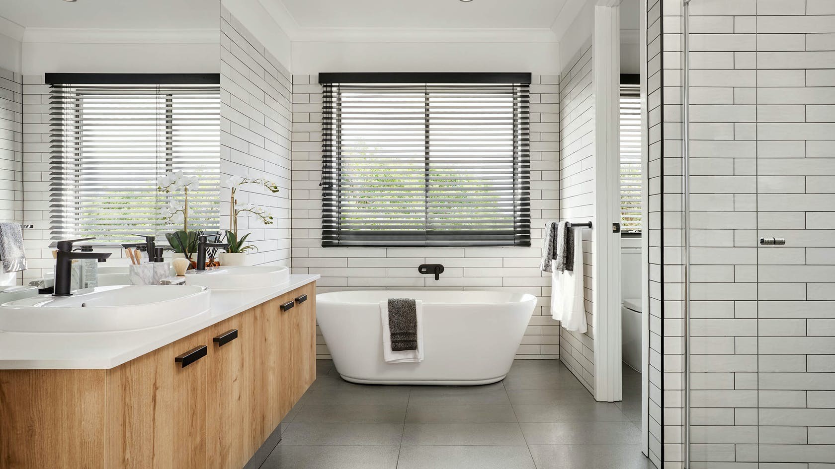 dark venetian blinds in modern black and white bathroom subtle tiles dark grout