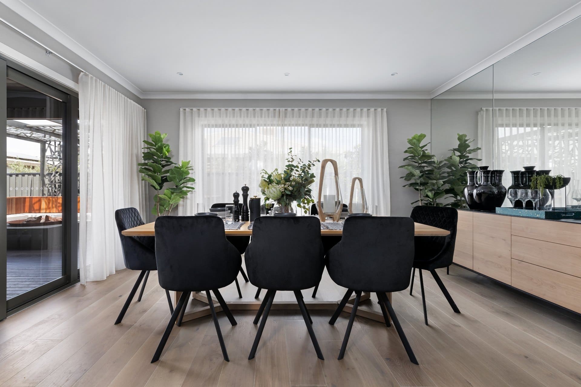 dining room with black fabric chairs and white sheer curtains with s fld heading