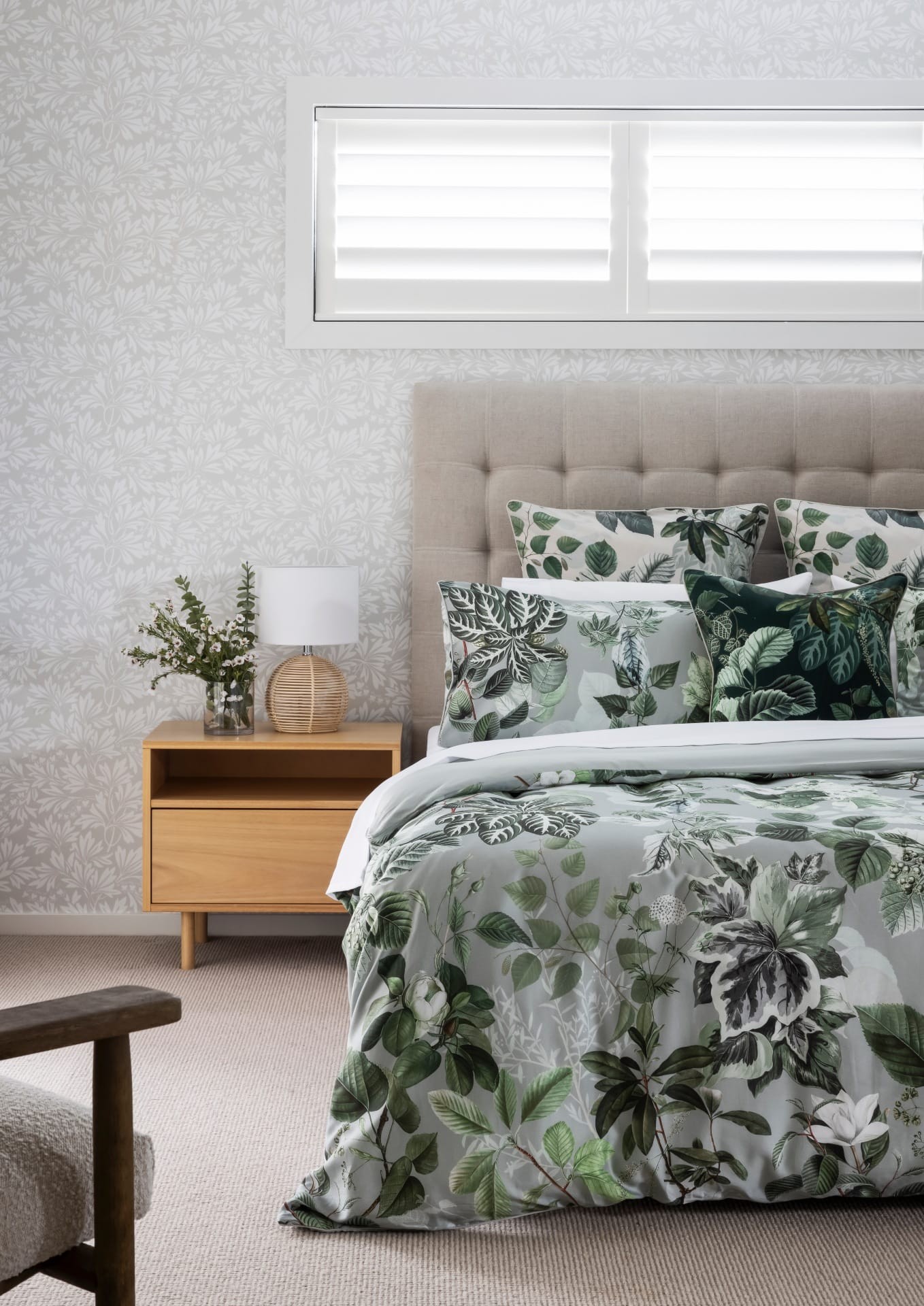 green and white leaf pattern bedding light timber bedside table and white leaf wallpaper