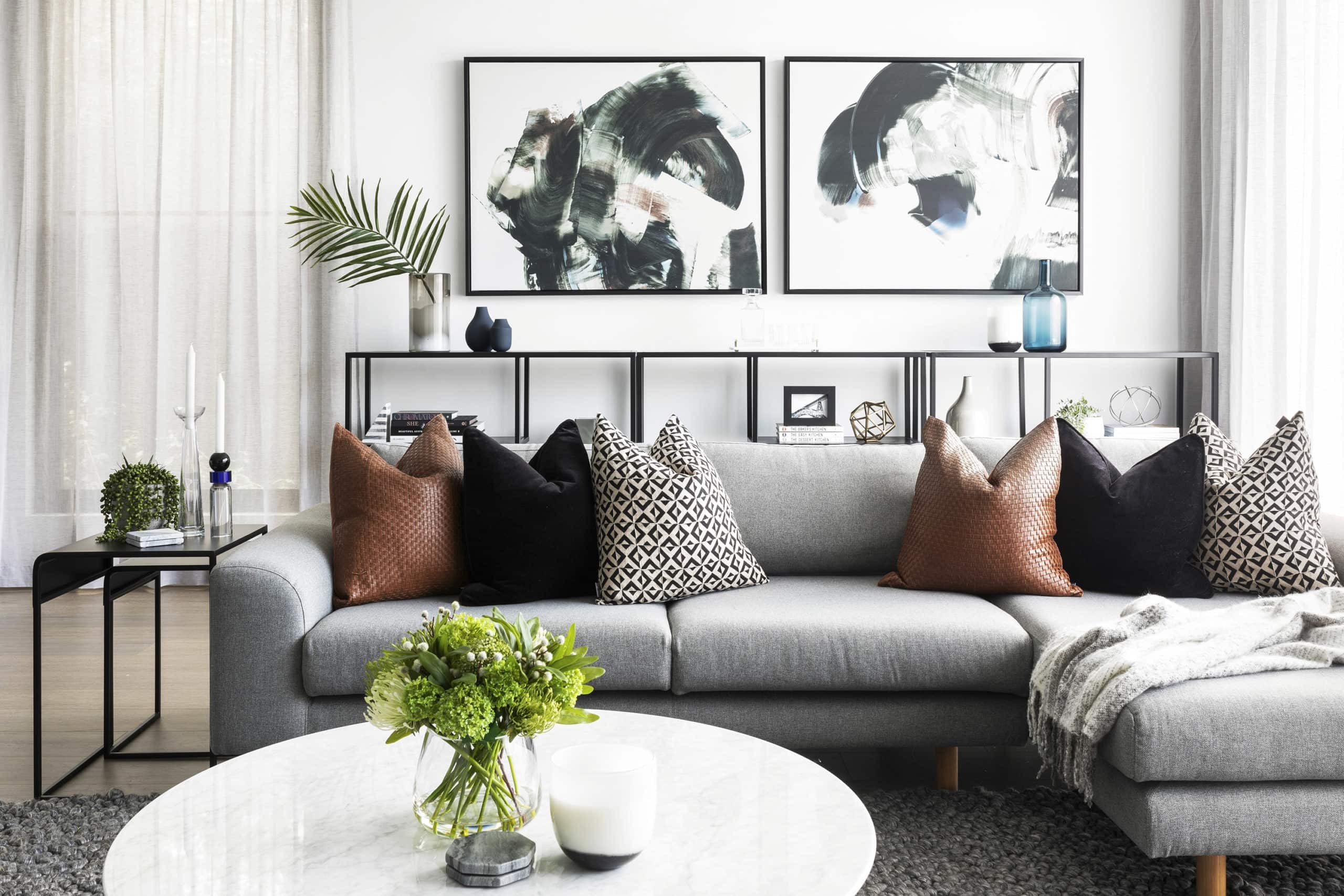 grey sofa with tan cushions and round marble coffee table in contemporary luxe living room