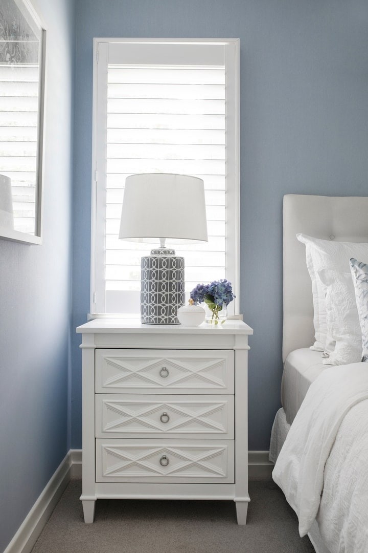 hamptons-bedroom-with-white-plantation-shutters-and-white-hamptons-bedside-table-blue-wallpaper