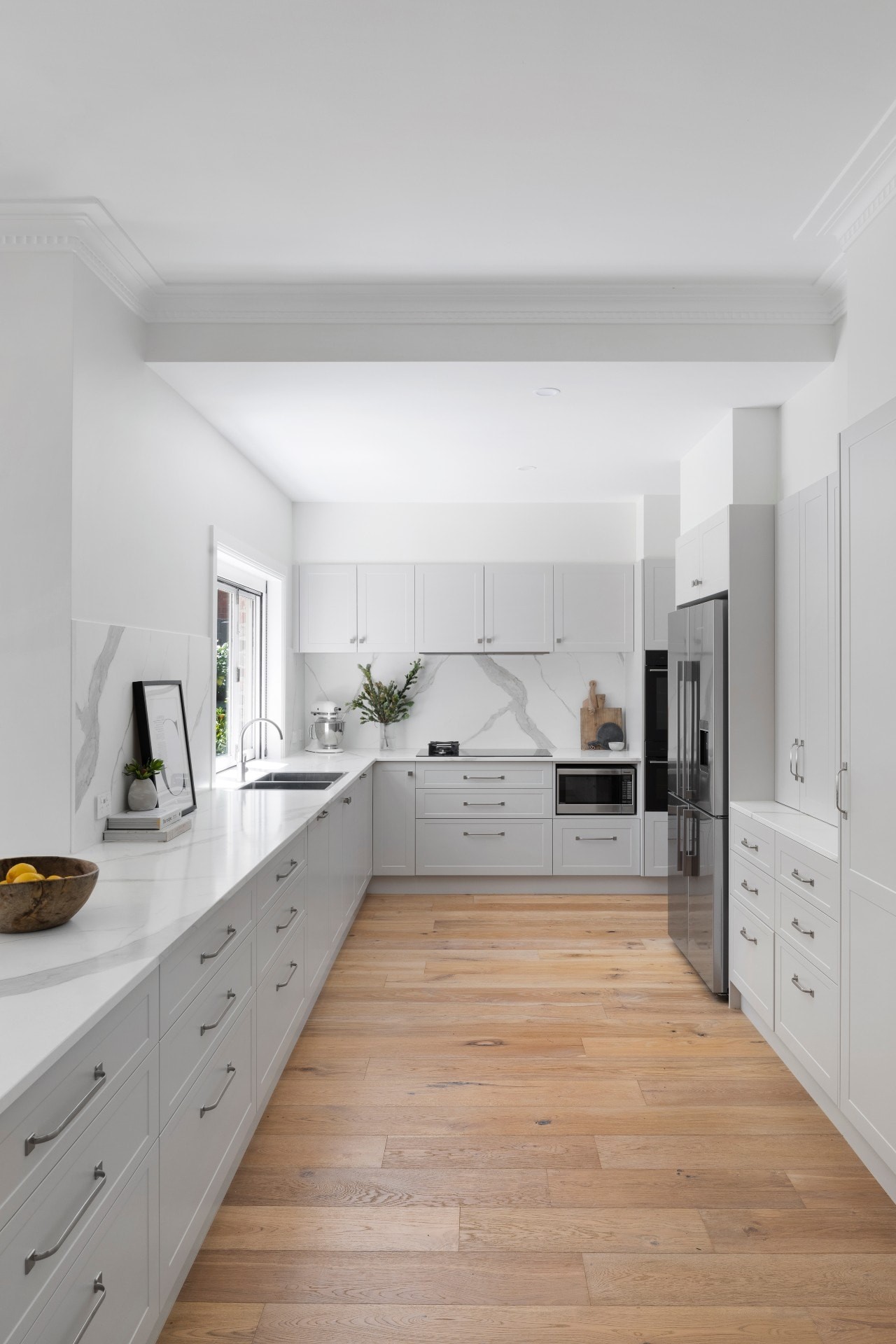 hamptons kitchen with grey shaker cabinets oak flooring white stone countertop servery window