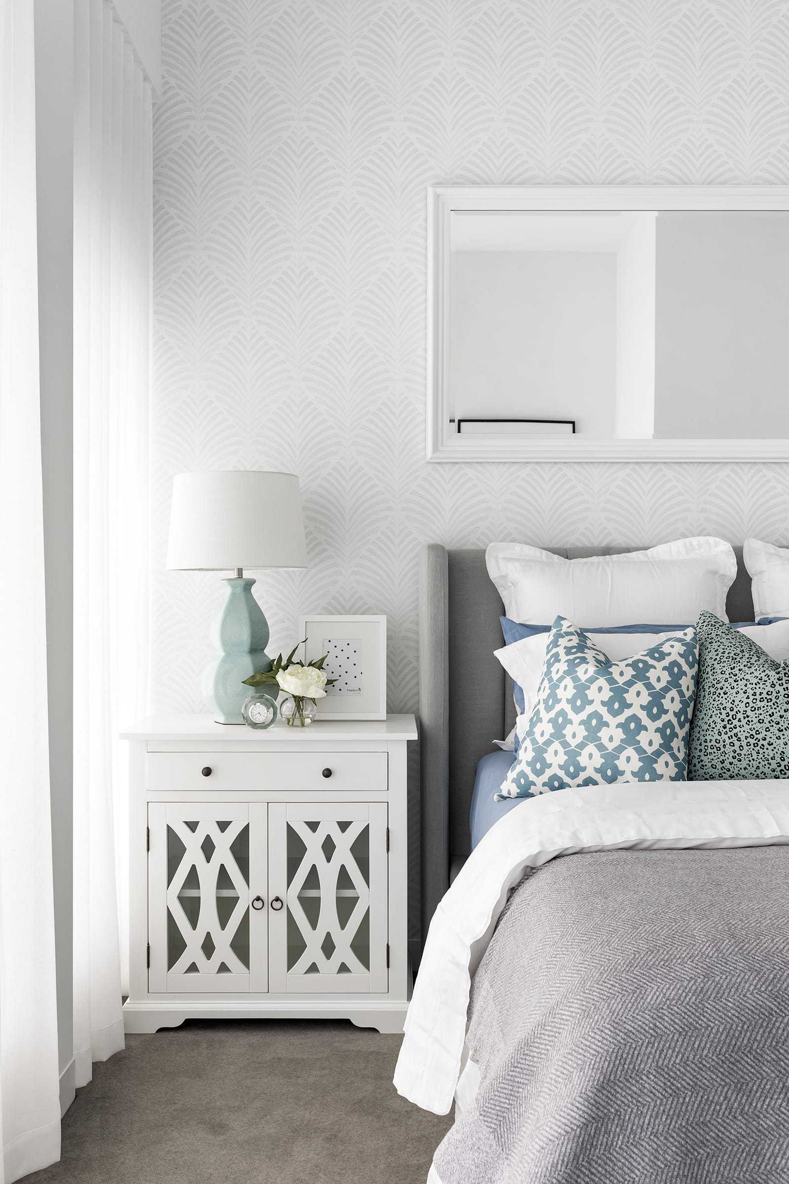hamptons master bedroom with grey and white wallpaper and white bedside tables
