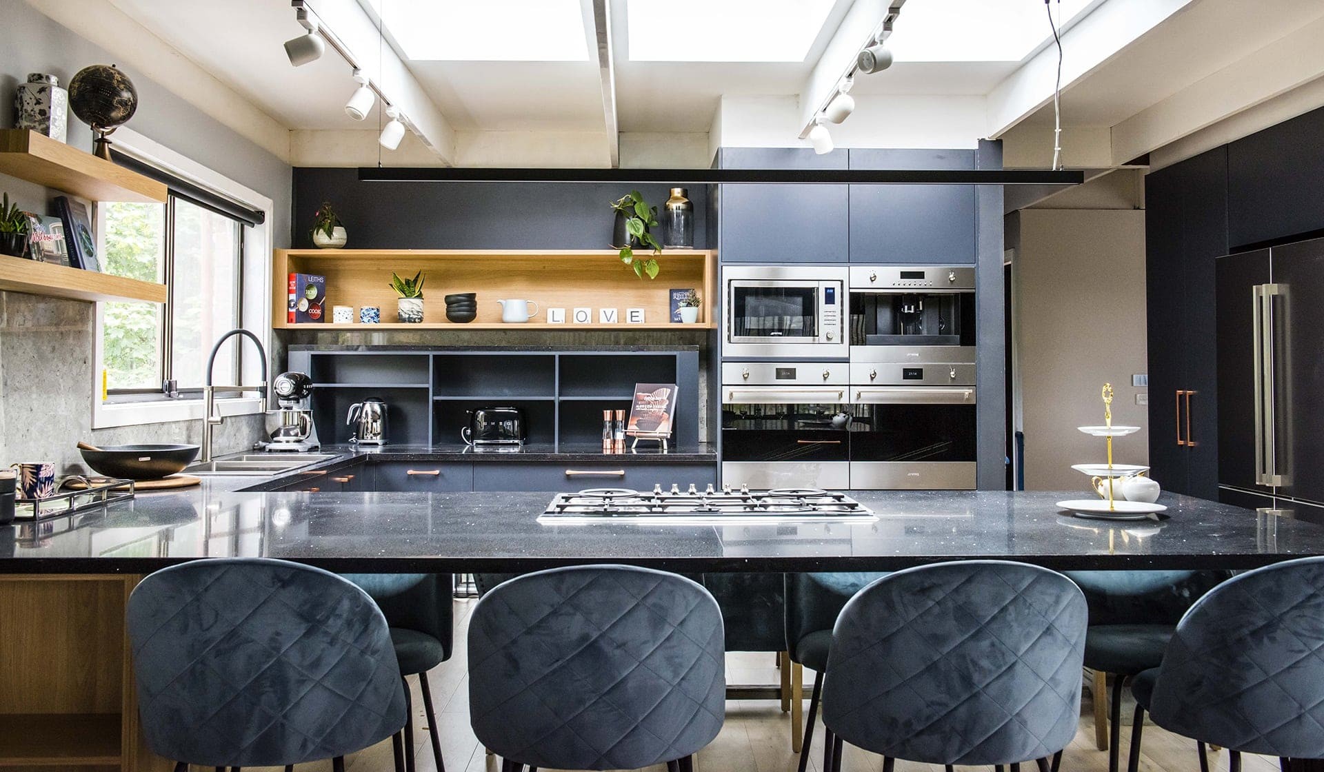 house rules 2019 pete and courtney kitchen with black countertop and blue cabinets