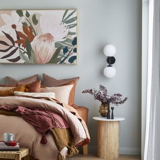 how to hang art above a bed floral art above pink and orange bedding