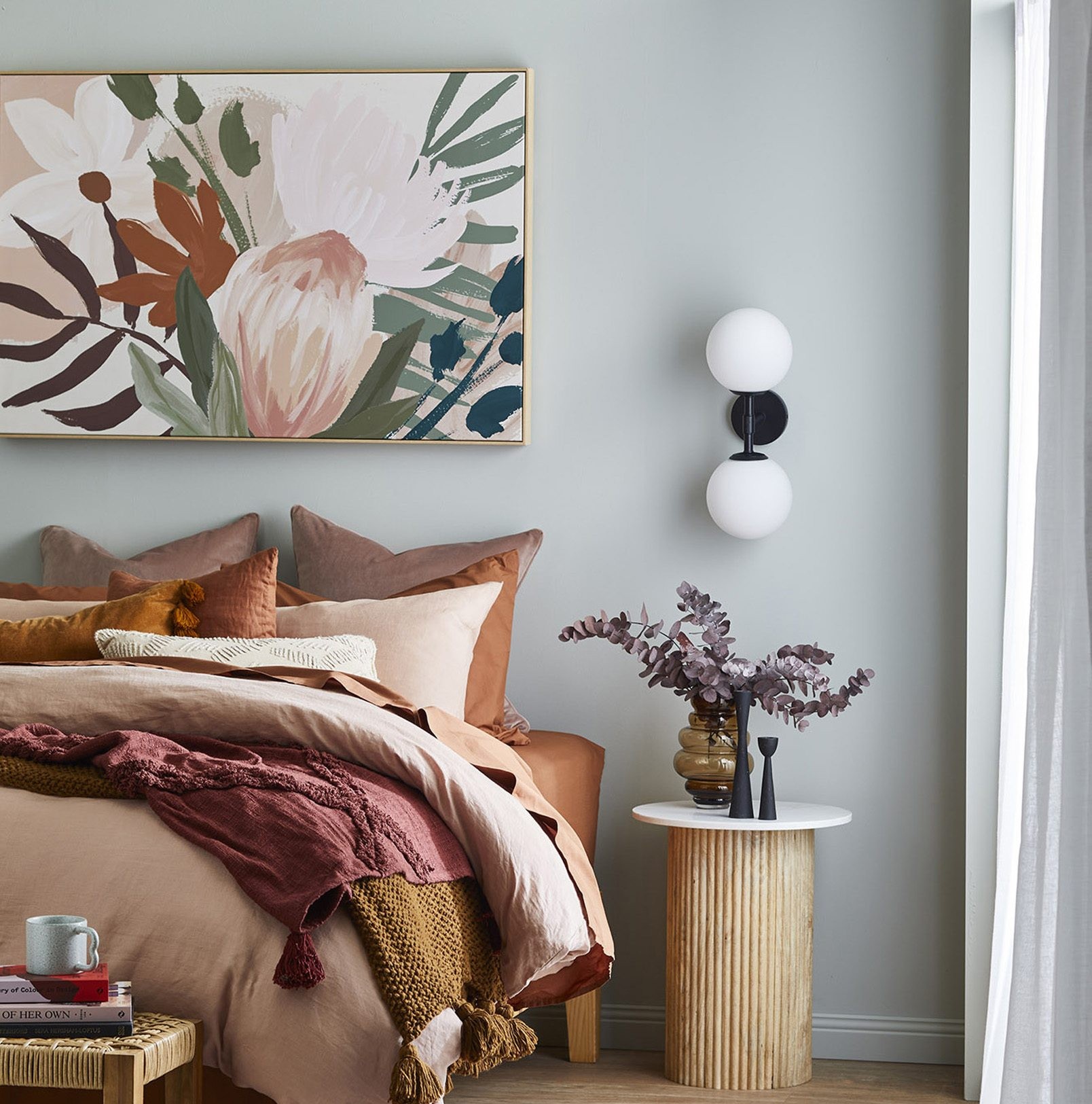 how to hang art above a bed floral art above pink and orange bedding