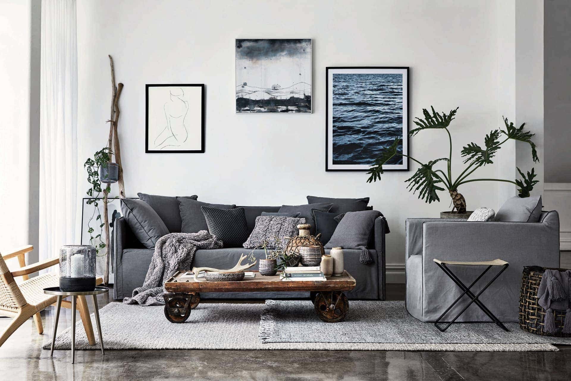 industrial coastal living room with grey slipcover sofa and industrial coffee table with wheels