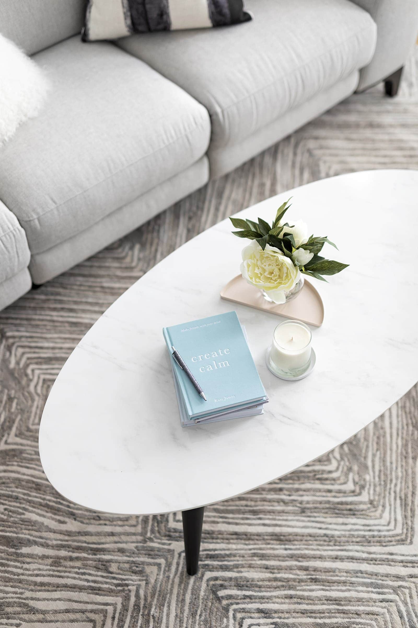 kmart stationery on oval marble coffee table from fantastic furniture and diamond rug from the rug collection