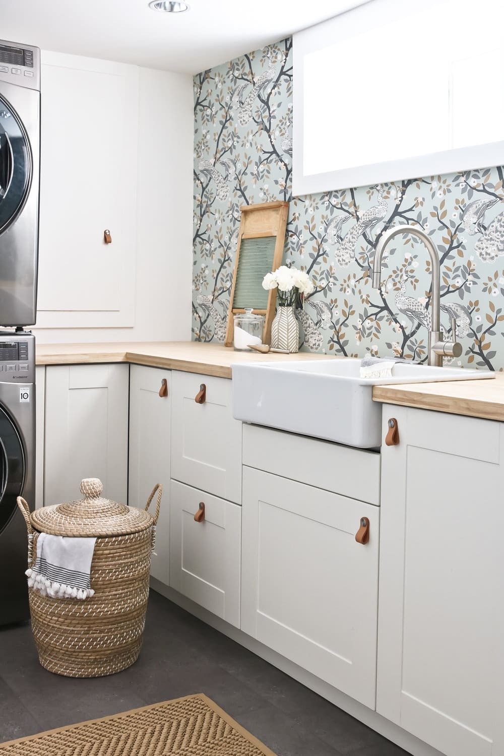 laundry room with floral wallpaper design and leather handles on cabinets