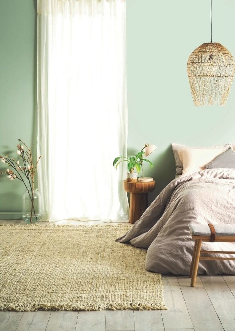 light green bedroom walls with taupe bed linen and sheer curtaisns from taubmans paint