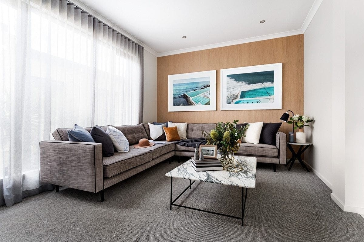 living room with grey sofa and navy and tan cushions in metricon display home
