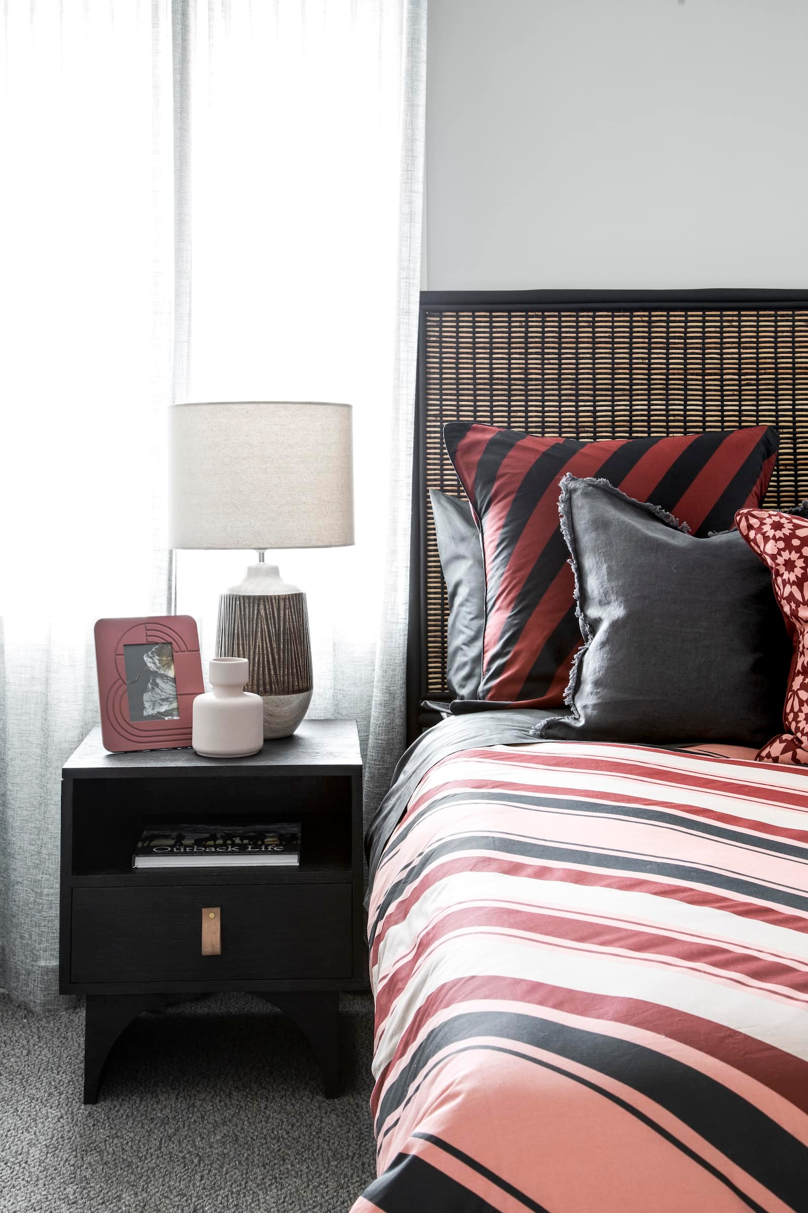 lorraine lea red and black stripe bedding in bedroom with black timber bedside tables