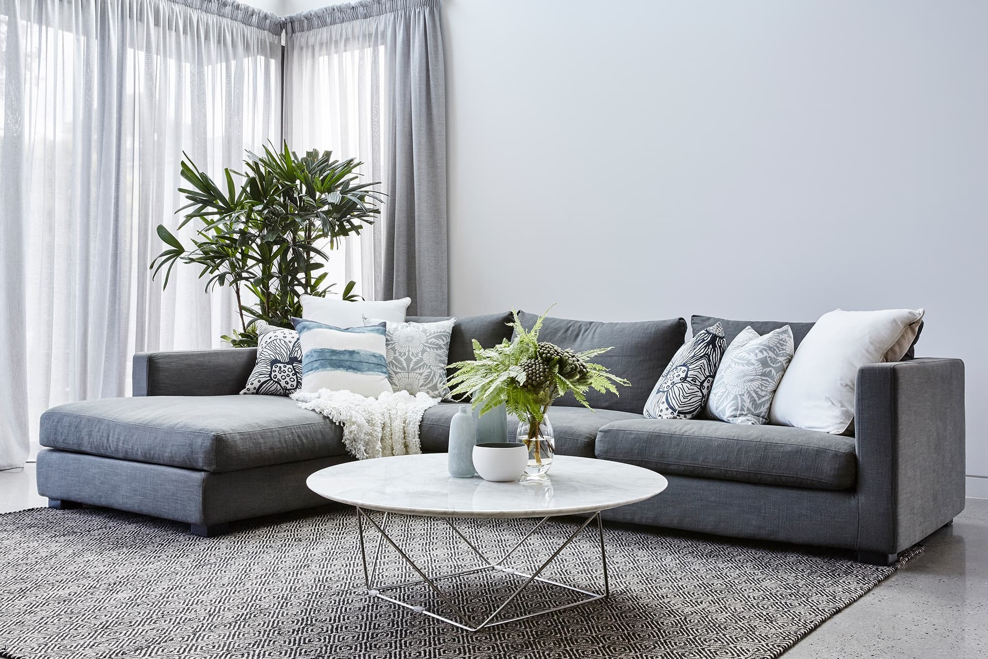 luxe coastal living room with polished concrete floor and globewest sofa by property styling melbourne