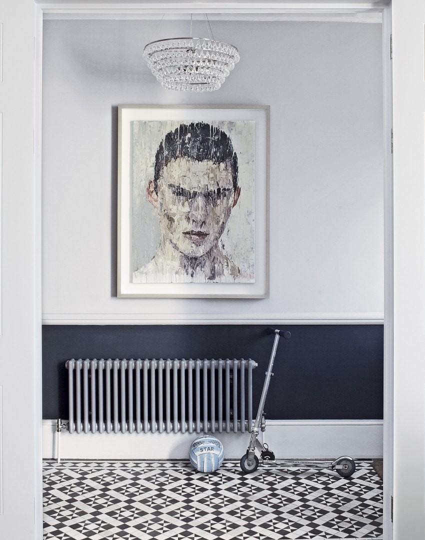 male head painting in white and navy hallway with black and white tiles