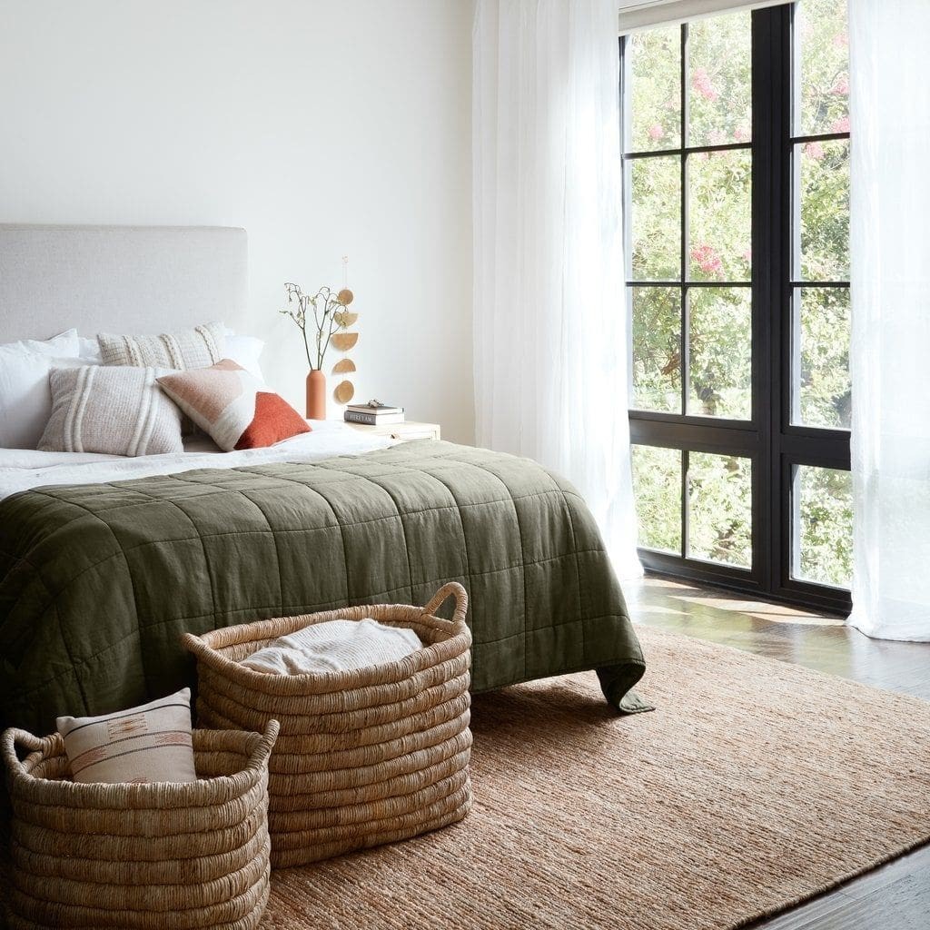 modern bedroom with white walls and jute rug under bed