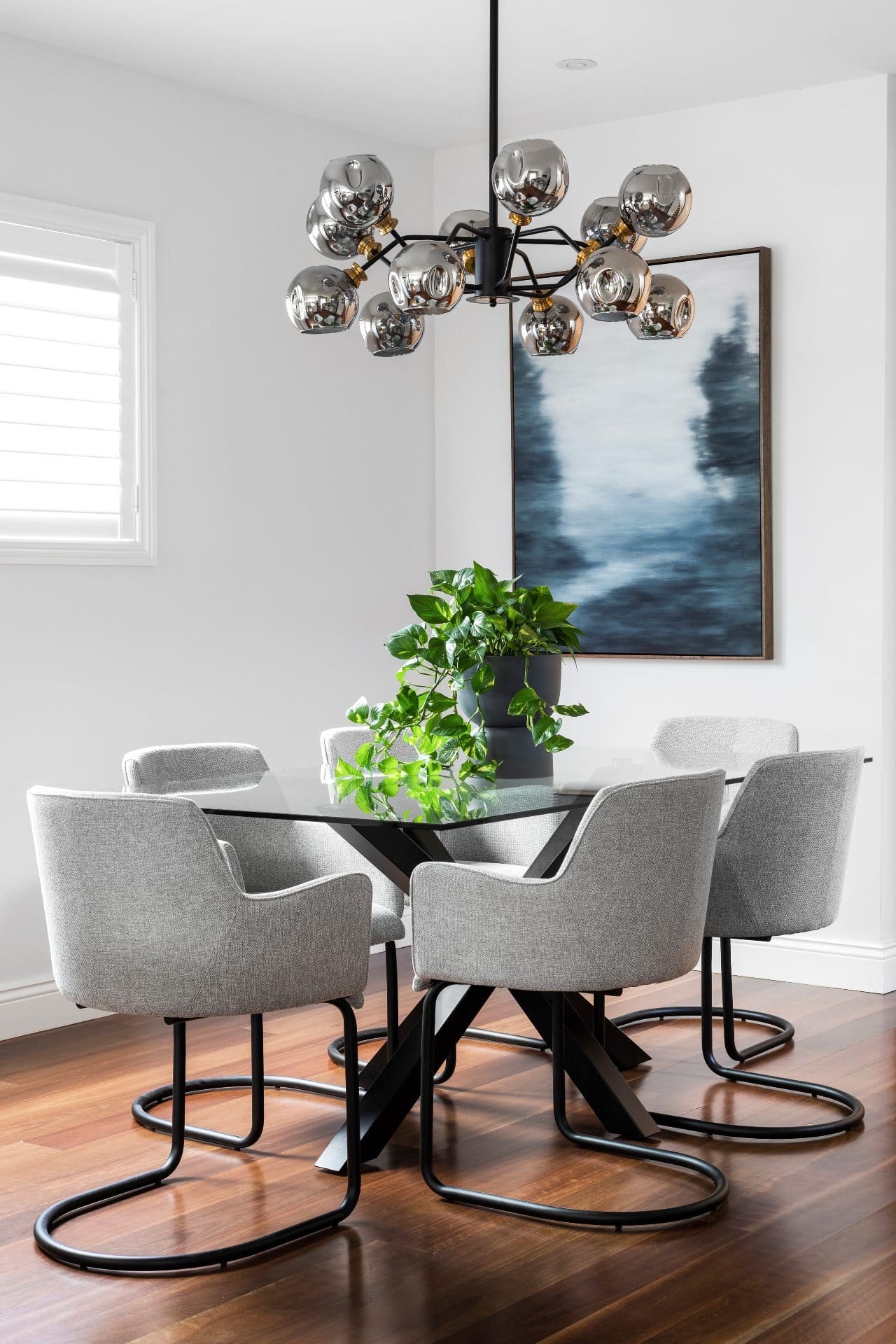 modern dining room design with glass rectangle dining table grey upholstered chairs and mid century glass pendant light