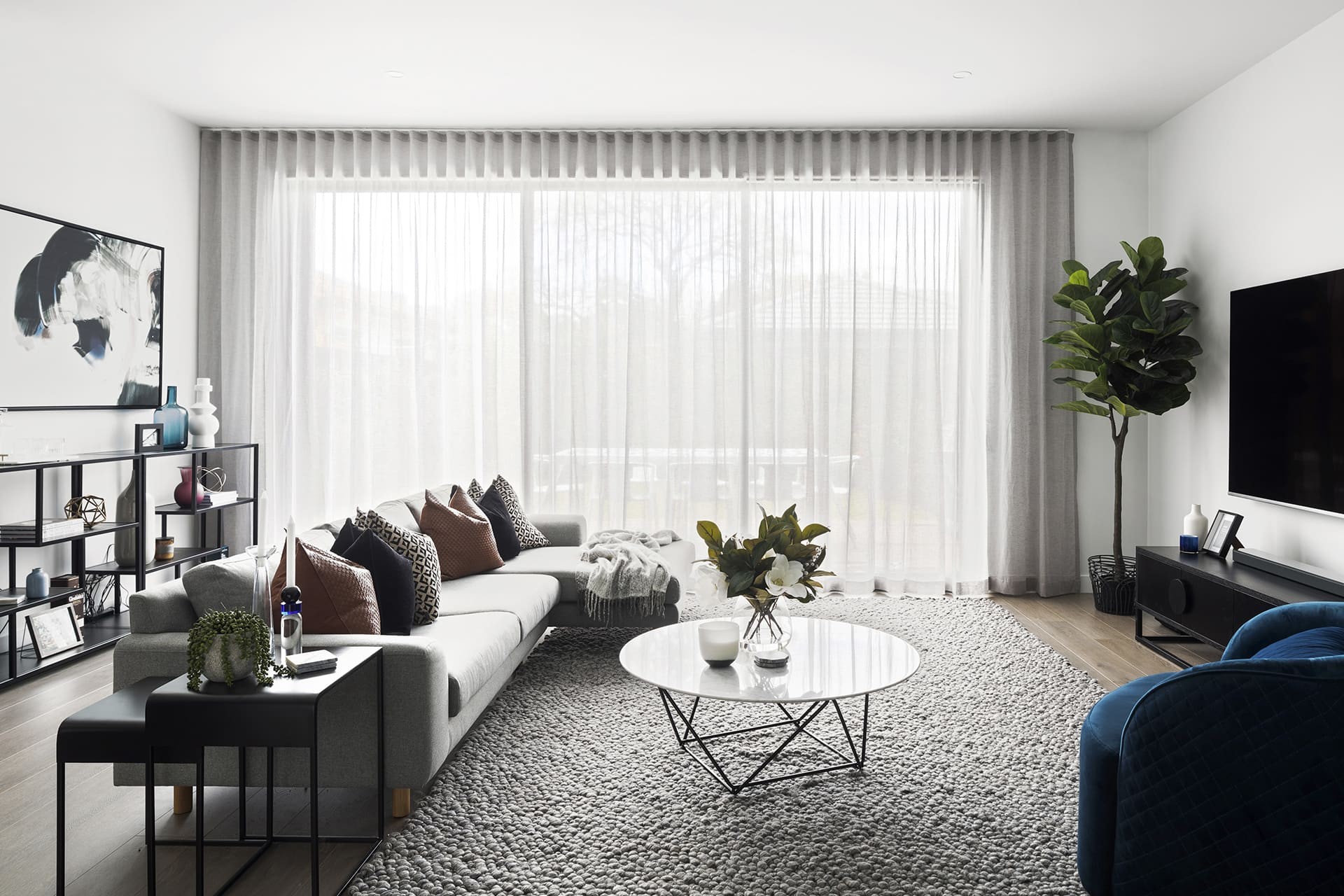 modern luxe living room with grey rug marble coffee table and sheer curtains