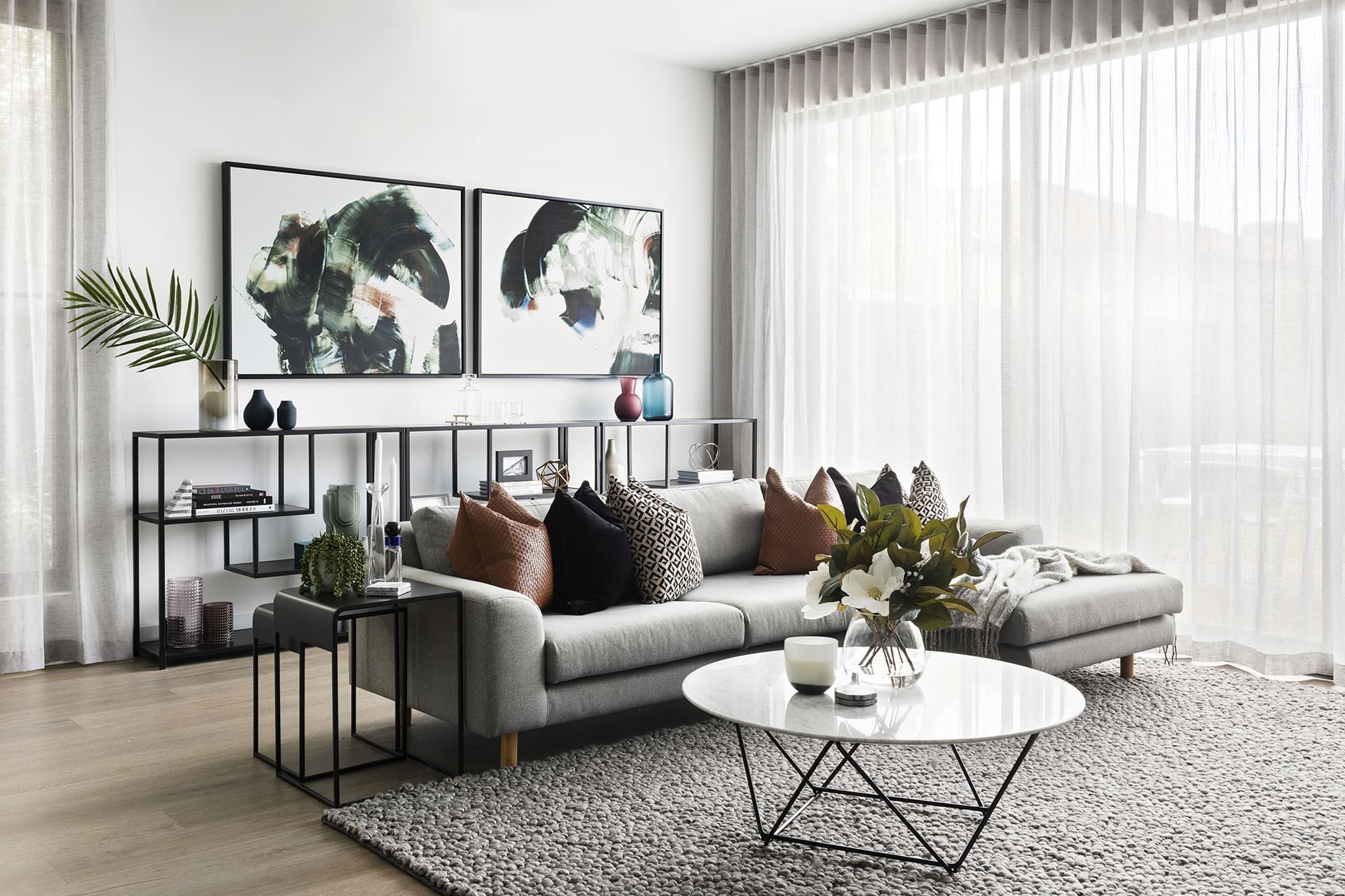 modern luxe living room with grey sofa tan leather cushions and marble coffee table