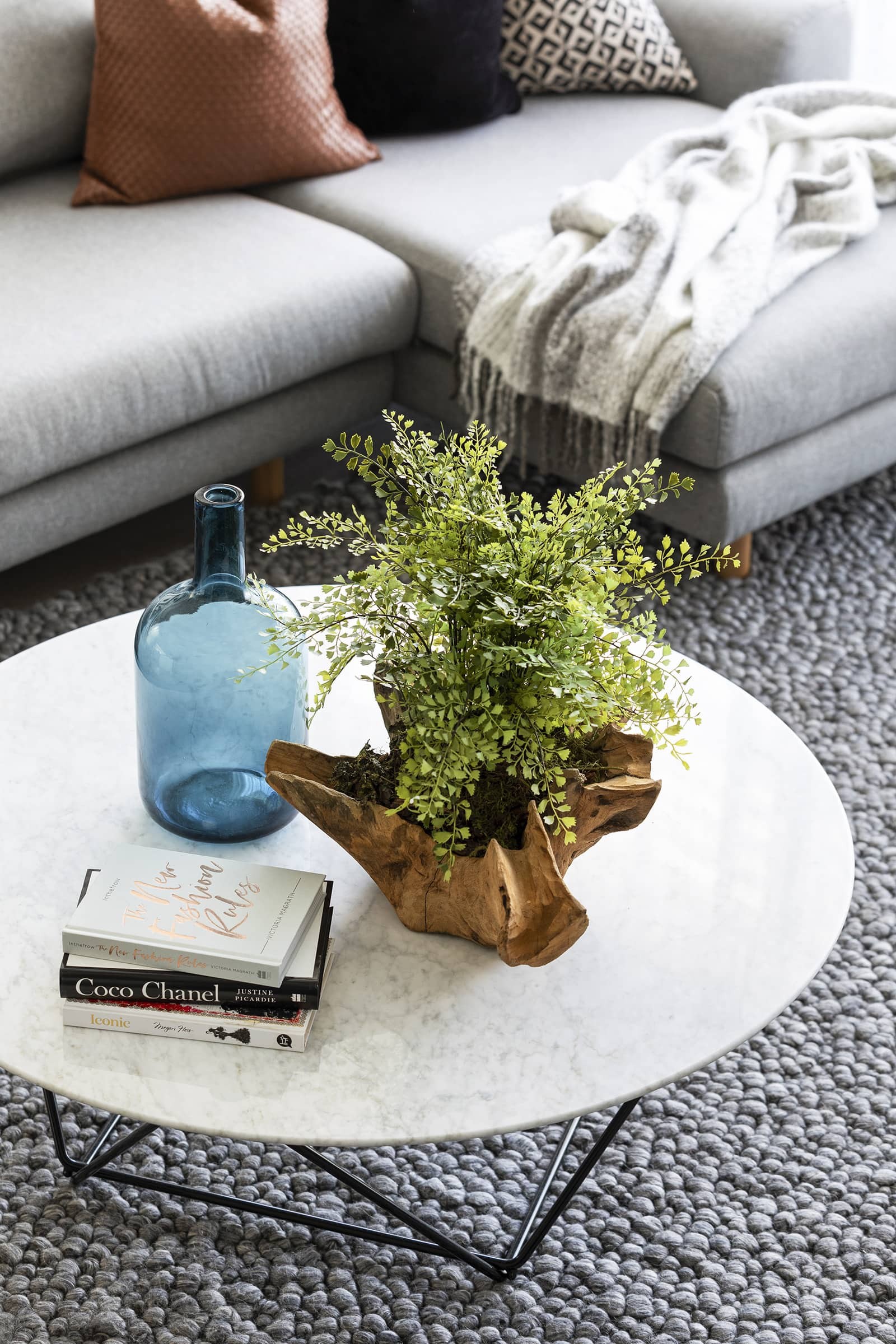 modern luxe living room with marble coffee table fake plant and blue glass vase from west elm