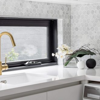 modern white laundry with marble hexagon tiles and brass tap