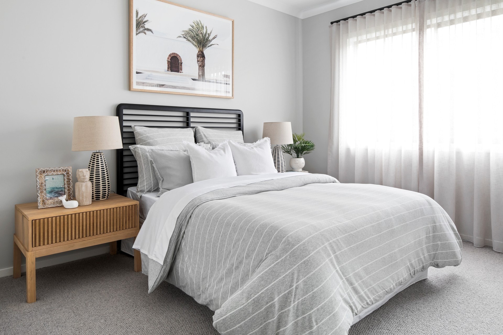 neutral grey and white bedroom with coastal timber bedside table and grey striped bedding
