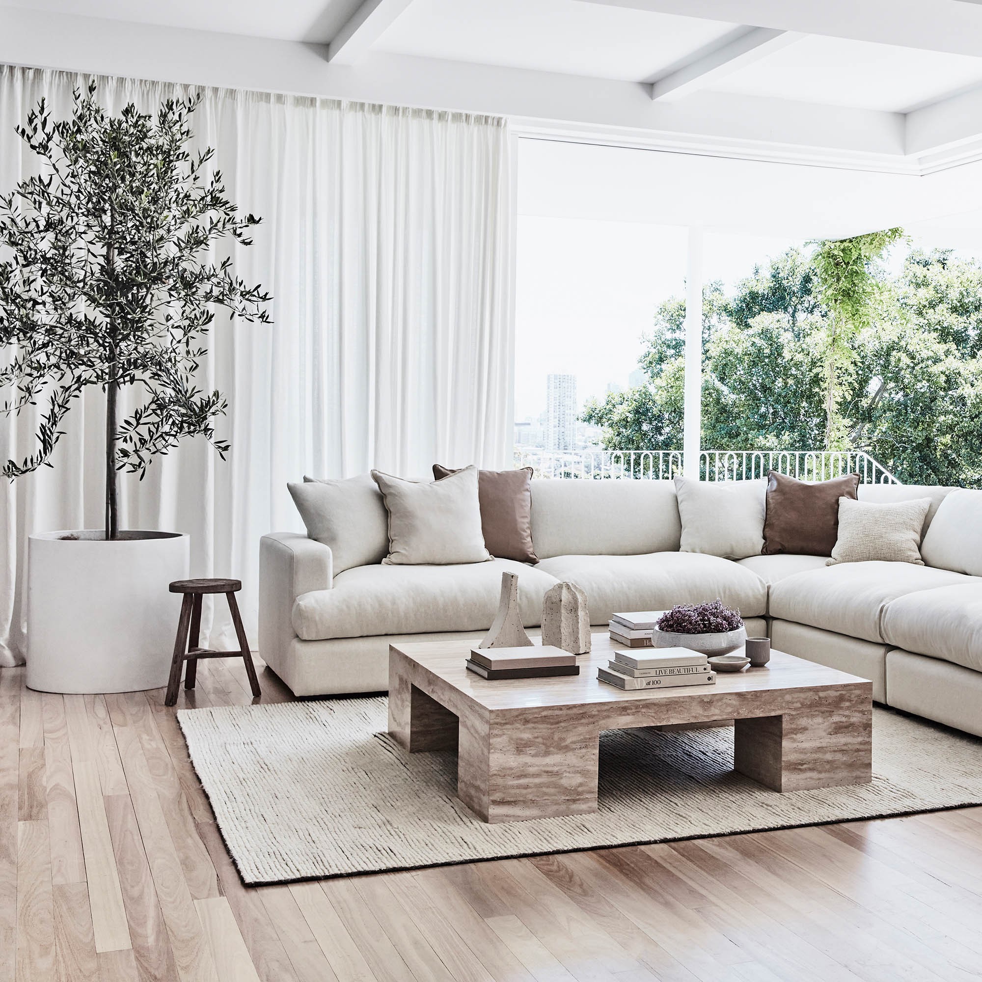 organic luxe living room with white sectional sofa and travertine coffee table