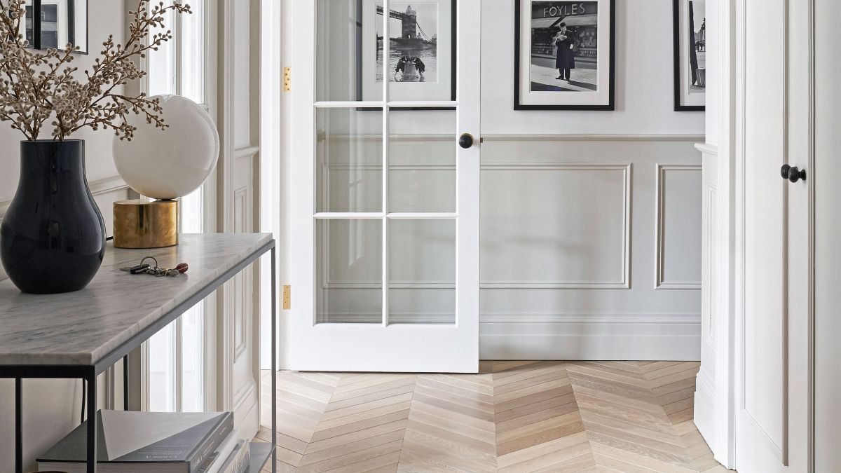 small long hallway with grey wainscoting and black and white photos