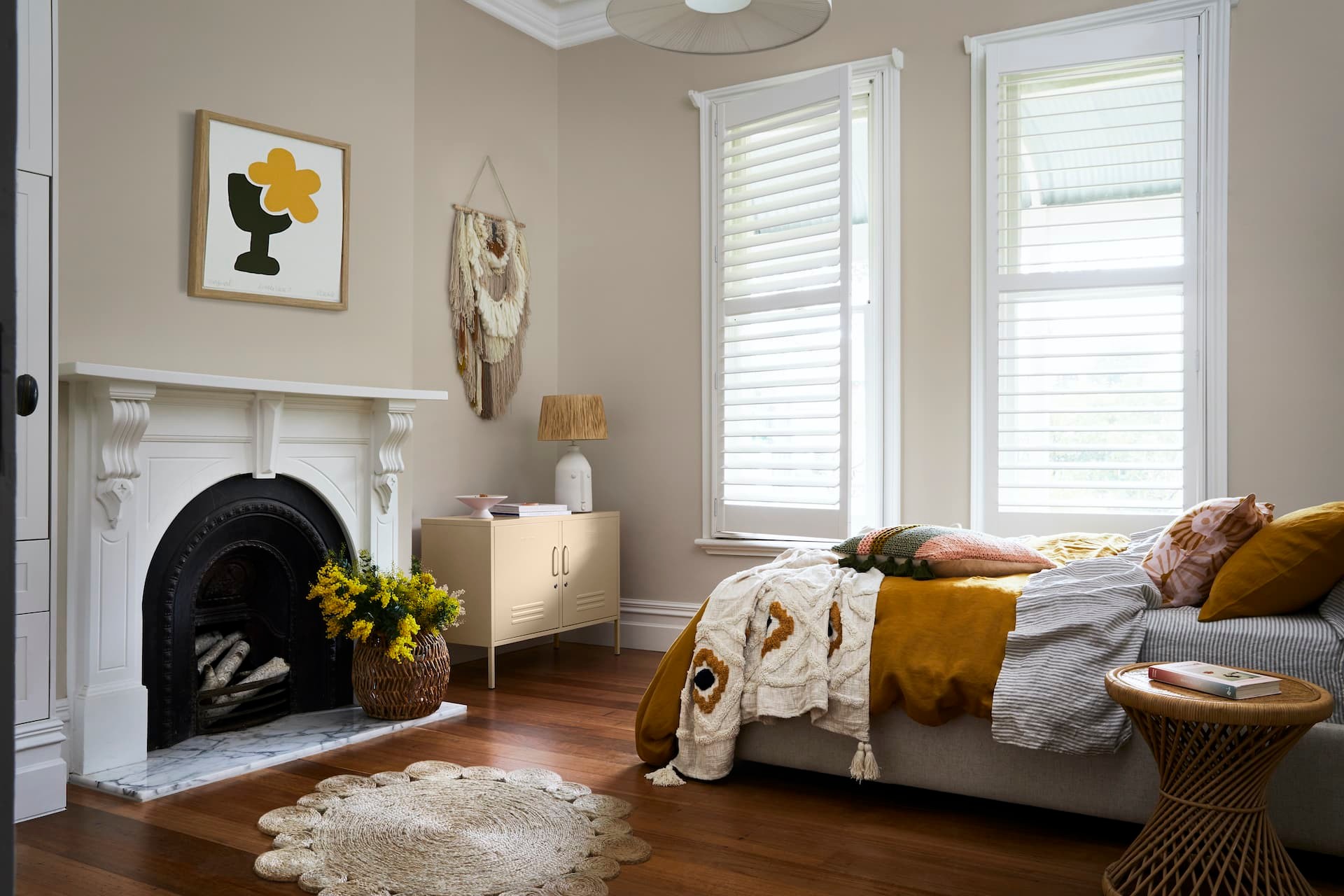 terrace house bedroom with beige walls white vintage fireplace and plantation shutters