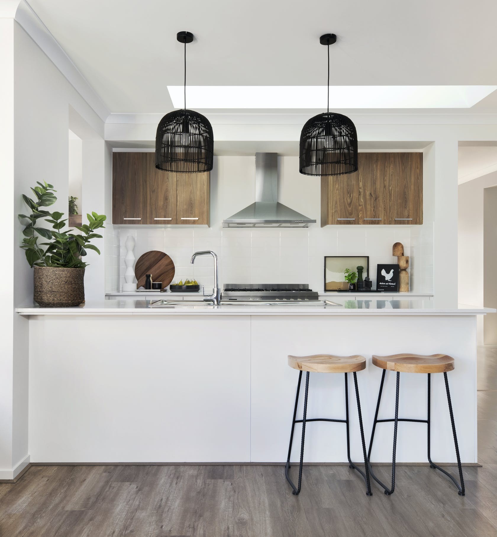 white and brown timber kitchen with black woven pendant lights