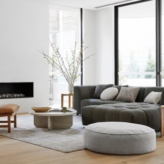 white and grey living room globewest with tan leather armchair and grey floor rug