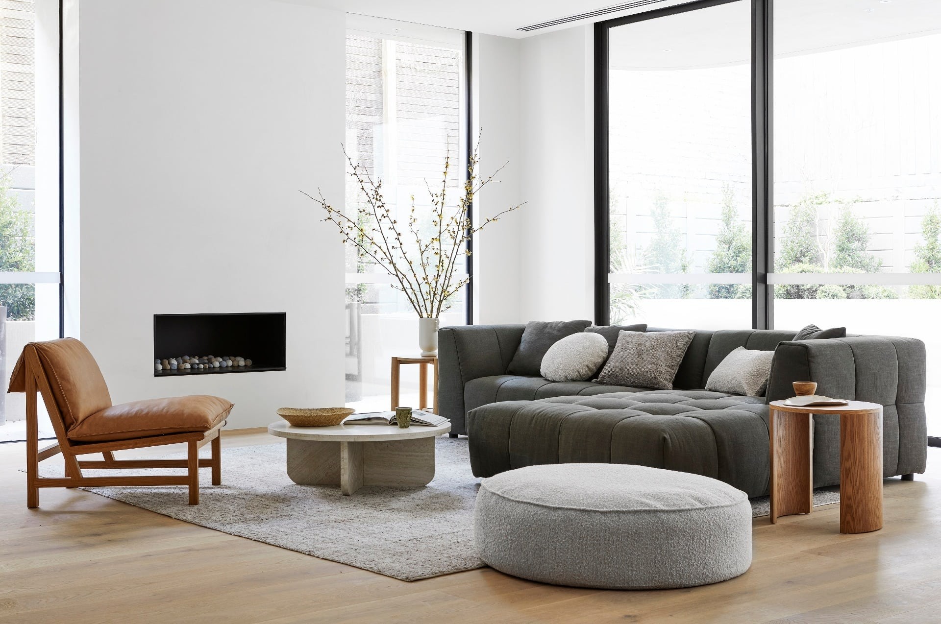 white and grey living room globewest with tan leather armchair and grey floor rug