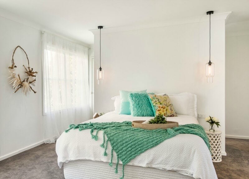 white bedroom with coastal style tropical green bedding and cushions
